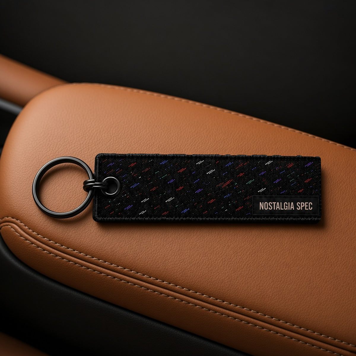 Nostalgia Spec Dealer Keychain, confetti, on tan leather armrest